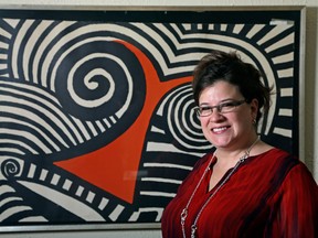 Karen Mallet stands in front of her Alexander Calder print in her Shorewood, Wis., home. Mallet bought the print for $12.34 at a Goodwill thrift store in Milwaukee. It turned out to be a lithograph by the American artist Alexander Calder worth $9,000. (AP Photo/Morry Gash)