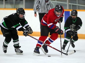 Danny Mailloux, centre, of Tecumseh Ketchup splits between Keegan Dimitrijevic, left, and Danny Mailloux, both of Powertech Panthers during the recent Hospice Hockey Tournament at Tecumseh Arena.  (NICK BRANCACCIO/The Windsor Star)