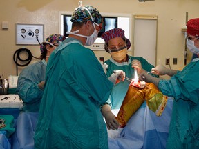 Registered Nurse First Assistants Pat Busteed, right, and Christina Cass, centre, in the operating room with Dr. Mike McCaffrey and operating room nurse Sue Mahoney, behind left, during a full knee replacement surgery at Hotel Dieu Grace Hosptial, November 11, 2010. (NICK BRANCACCIO/THE WINDSOR STAR)