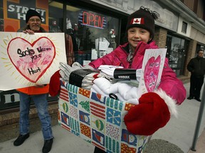 In this file photo, Sarah Lewis, 9, hands out new packages of socks to area homeless and needy families at Street Help/Unit 7 drop in centre on Wyandotte Street East Friday December 11, 2009.  (Windsor Star files)