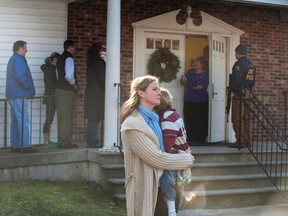 A woman holds a child as people line up to enter the Newtown Methodist Church near the the scene of an elementary school shooting on December 14, 2012 in Newtown, Connecticut. According to reports, there are about 27 dead, 18 children, after a gunman opened fire in at the Sandy Hook Elementary School. The shooter was also killed.  (Photo by Douglas Healey/Getty Images)