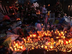 Candles are lit among mementos at a memorial for victims of the mass shooting at Sandy Hook Elementary School, on December 17, 2012 in Newtown, Connecticut. The first two funerals for victims of the shooting were held today.  (Photo by Mario Tama/Getty Images)