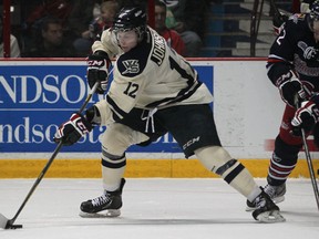 Windsor's Ben Johnson backhands a shot while being checked by Oshawa's Boone Jenner at the WFCU Centre.  (DAX MELMER/The Windsor Star)