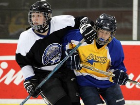 St. Anne's Ashley Maitre, right, is checked by St. Christopher's Abby Whitely at the Southern Ontario High School Hockey Classic Monday at the WFCU Centre. (NICK BRANCACCIO/The Windsor Star)