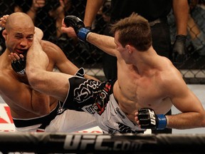 Rory MacDonald, right, kicks BJ Penn in the third round of a welterweight mixed martial arts bout at a UFC on FOX event in Seattle, Saturday, Dec. 8, 2012. MacDonald won by unanimous decision. (AP Photo/Jeff Chiu)