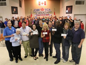 The Canadian Auto Workers union local 200 donated a total of $30,000 to six local charitable organizations Monday, Dec. 17, 2012, in Windsor, Ont. Posing with the cheques, from left, are Dan Cassady, CAW financial secretary, Eileen Clifford, Essex Food Bank, Ron Dunn, Downtown Mission, Jennifer Cline, Well-Come Centre, Chris Taylor, CAW local 200 president, June Muir and Mike Turnbull, Unemployed Help Centre, Timothy McAllister, Amherstburg Food and Fellowship Mission, Cathy Masse, Lakeshore Community Food Bank and Marc Renaud, CAW local 200 vice-president. (DAN JANISSE/The Windsor Star)