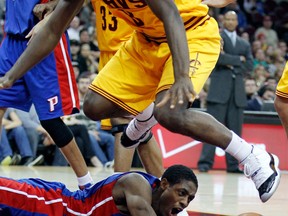 Detroit Pistons' Brandon Knight, bottom, loses control of the ball as Cleveland Cavaliers' Jeremy Pargo jumps over him in the fourth quarter of an NBA basketball game Saturday, Dec. 8, 2012, in Cleveland. The Pistons won 104-97. (AP Photo/Tony Dejak)