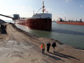 Jack Frye, centre, COO of Southwestern Sales Corp., Mark Durham, operations, and Harbourmaster Peter Berry walk beside the newest Canada Steamship Lines vessel Baie St. Paul which arrived from a shipyard in China December 18, 2012. CSL freighter Atlantic Huron, right, heads upstream on the Detroit River. (NICK BRANCACCIO/The Windsor Star)