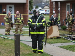 Windsor firefighters work at the scene of a fire Monday, Dec. 10, 2012, in a row house on Garden Court in Windsor, Ont. A male leaving in the unit was taken to hospital with undetermined injuries. (DAN JANISSE/The Windsor Star)