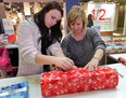 Karen Waddell (R), executive director of the House of Sophrosyne and her daughter Samantha wrap a gift Thursday, Dec. 20, 2012, at the Devonshire Mall in Windsor, Ont. It is a fundraiser for organization. (DAN JANISSE/The Windsor Star)