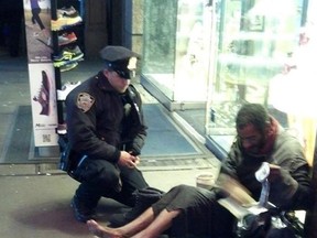 This photo provided by Jennifer Foster shows New York City Police Officer Larry DePrimo presenting a barefoot homeless man in New York's Time Square with boots Nov. 14, 2012 .
(AP Photo/Jennifer Foster)