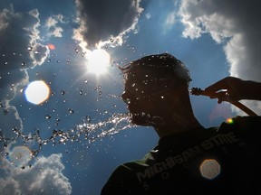 A man cools off with water in this file photo. (Jason Kryk/The Windsor Star)