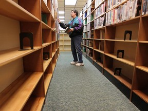 Books have been removed from lower shelves at the Leamington Public Library in a far corner of the building. An unknown person has been urinating on the books and damaging them. Barb Newman, a regular visitor to the library checks out some books Monday, Dec. 10, 2012. (DAN JANISSE/The Windsor Star)