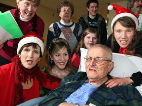 While recovering at Windsor Regional Hospital Met campus, Arthur Shields, centre, receives a surprise Christmas concert from choir members of St. Mark's By-the-Lake Church Monday, December 24, 2012.  Choir singers Nicky Adams, left, Andrea Morosin and Shields' granddaughter Alanah Shields, behind.  Singers Bev Watson, top left, Jackie Farrow, Mitchell Shields and Robert Hubbard, right, brought their musical talent during their visit. (NICK BRANCACCIO/The Windsor Star)