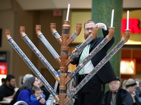 Rabbi Sholom Galperin pours hundreds of pennies into a giant coin Menorah during an event on the third day of Chanukah at Devonshire Mall Monday December 10, 2012.  Chanukah celebration is held every year at Devonshire Mall with Rabbi Galperin responsible for a giant Menorah made of Lego pieces and food cans in previous years.  This year's coin Menorah holds 70,000 pennies and is sponsored by Chabad Jewish Centre and the Jewish community. (NICK BRANCACCIO/The Windsor Star)