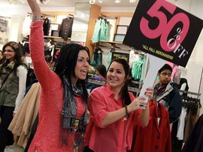 Melanie Kennedy, left, and Brittany Ganderup do their best to lure in shoppers at the Devonshire Mall in Windsor, Ont. on Wednesday, December 26, 2012. Local retailers rolled out their best deals for the annual Boxing Day sales.          (TYLER BROWNBRIDGE / The Windsor Star)