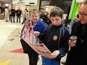 Fany Seguin-Thompson, left, Andre Seguin and Philip Seguin check the Boxing Day flyer while waiting in line outside EB Games at Devonshire Mall in Windsor, Ont. on Wednesday, December 26, 2012. Local retailers rolled out their best deals for the annual Boxing Day sales.          (TYLER BROWNBRIDGE / The Windsor Star)