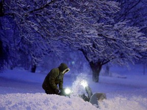 In this file photo, a local resident clears snow from his driveway after an overnight snowfall left many schools and businesses closed for the day, Thursday, Dec. 20, 2012, in Urbandale, Iowa. (AP Photo/Charlie Neibergall)