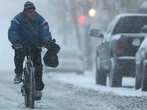 A man rides his bike on University Avenue in downtown Windsor as a winter storm hits the Windsor area, Wednesday, Dec. 26, 2012.  (DAX MELMER/The Windsor Star)
