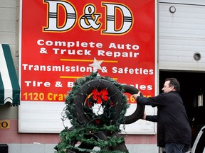 Gil Drouillard places another tire on his Christmas tree built from old automobile tires at D & D Truck Repair on Crawford Avenue December 19, 2012. (NICK BRANCACCIO/The Windsor Star)