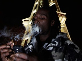 Allister Adams smokes marijuana, Thursday, Dec. 6, 2012, just after midnight at the Space Needle in Seattle. Possession of marijuana became legal in Washington state at midnight, and several hundred people gathered at the Space Needle to smoke and celebrate the occasion, even though the new law does prohibit public use of marijuana. (AP Photo/Ted S. Warren)