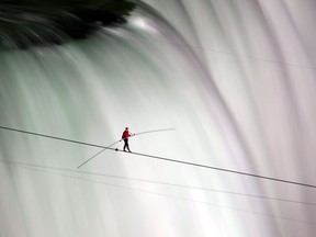 n this June 15, 2012 file photo, Nik Wallenda walks over Niagara Falls on a tightrope in Niagara Falls, Ontario. Wallenda finished his attempt to become the first person to walk on a tightrope 1,800 feet across the mist-fogged brink of roaring Niagara Falls. The seventh-generation member of the famed Flying Wallendas had long dreamed of pulling off the stunt, never before attempted. (AP Photo/The Canadian Press, Frank Gunn, File)