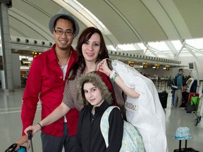 Krisztina Sebesi (centre) poses with her fiance Rex Lu and ten-year-old daughter Salena as they depart Pearson Airport in Toronto on Saturday December 8, 2012 for their Dec. 12 wedding in Aruba. As if getting engaged on New Year's Eve wasn't enough of a milestone, Krisztina Sebesi and Rex Lu are upping the ante with their choice of a once-in-a-century wedding date. They are set to exchange vows during a sunset ceremony in Aruba on Wednesday, Dec. 12, 2012 - or 12-12-12. THE CANADIAN PRESS/Frank Gunn