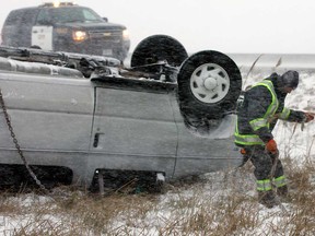 Myers Towing operator Brian Clement fights a strong wind at the scene of a rollover on Hwy 401 near Lakeshore Road 123, Wednesday December 26, 2012.  OPP and Essex-Windsor EMS paramedics responded to the scene where a Ford E-350 passenger van lost control and overturned in the westbound ditch.  (NICK BRANCACCIO/The Windsor Star)