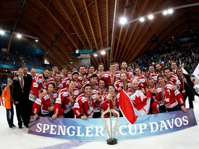 The players of Team Canada celebrate with the winner's trophy after Team Canada won the after final match between Team Canada and HC Davos at the 86th Spengler Cup ice hockey tournament, in Davos, Switzerland, Monday, Dec. 31, 2012. (AP Photo/Keystone, Salvatore Di Nolfi)