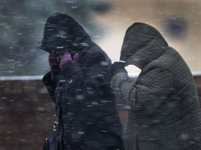 Pedestrians shield themselves from the wind and snow in this file photo.  (DAN JANISSE/The Windsor Star)