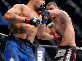 Junior dos Santos of Brazil, left, and Cain Velasquez of San Jose throw punches during their UFC 155 heavyweight championship mixed martial arts match at the MGM Grand Garden Arena Saturday in Las  Vegas. (AP photo/David Becker)