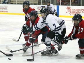 Macomb's Nick Cvetanovski, centre, is checked by Windsor's Brett Johnson, from left, Aaron Jacobs and Dylan Guthrie at the 53rd Riverside bantam-midget hockey tournament at the WFCU Centre.  (DAX MELMER/The Windsor Star)