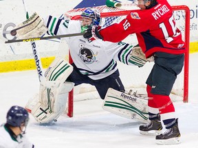 Windsor's Kerby Rychel, right, tips a shot in front of Plymouth goalie Matt Mahalak. (Photo courtesy of Plymouth Whalers)