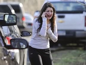 A woman waits to hear about her sister, a teacher, following a shooting at the Sandy Hook Elementary School in Newtown, Conn., about 60 miles (96 kilometers) northeast of New York City, Friday, Dec. 14, 2012. An official with knowledge of Friday's shooting said 27 people were dead, including 18 children. It was the worst school shooting in the country's history. (AP Photo/Jessica Hill)