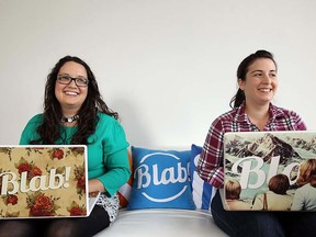 Katie Stokes, left, and Jessica Apolloni, owners of Blab Media, have some fun with signs at their Windsor office (TYLER BROWNBRIDGE / The Windsor Star)