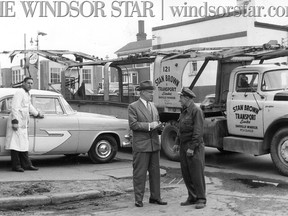 June 27/1956-All cars delivered, finally with the last car delivered and his transport empty, Mr. Loiselle gets the bills signed by William Gardiner of Sudbury, one of the longest established auto dealers in the province. He will make the return trip with an empty trailer. (The Windsor Star-FILE)