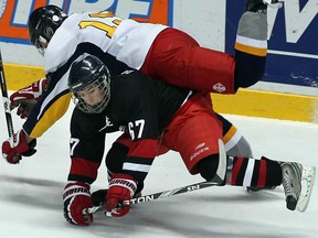 Brennan's Aaron Galbraith, bottom, collides with St. Joseph's Colton Ross during the Father Zakoor Cup at WFCU Centre, Thursday December 20, 2012. (NICK BRANCACCIO/The Windsor Star)