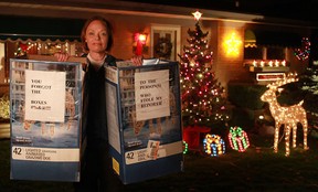 Grace Zebic holds two boxes that Dennis Grubka placed on his lawn after two decorative reindeer went missing, Monday, Dec. 10, 2012.  The notes on the boxes read 'To the person(s) who stole my reindeer...you forgot the boxes #%&@!!!'  (DAX MELMER/The Windsor Star)