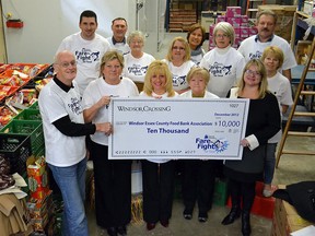 Colleen Gosnell, (right, front),  presents a cheque for $10,000 to the Windsor-Essex Food Bank Association at the Unemployed Help Centre Food Bank in Windsor, Ontario on December 5, 2012. (Photo by Hailey Trealout)
