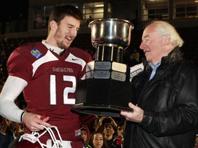 McMasters University Marauders quarterback Kyle Quinlan receives the Mitchell Bowl, from Doug Mitchell, after defeating the University of Calgary Dinos in CIS football action in Hamilton, Ontario, on Saturday, Nov. 17, 2012. THE CANADIAN PRESS/Dave Chidley