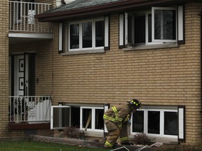 WINDSOR, ONT.:DECEMBER 1, 2012 -- A Windsor firefighter looks through a broken window at 2835 McKay Avenue where a residential fire broke out shortly after 8 a.m., Saturday, Dec. 1, 2012.  The cause of the fire is still under investigation.  No injuries were reported.  (DAX MELMER/The Windsor Star)