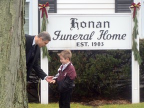 A man speaks to his young son December 17, 2012 at the funeral for Jack Pinto, 6, one of the victims of the December 14, Sandy Hook elementary school shooting, in Newtown, Connecticut.  Funerals began Monday in the little Connecticut town of Newtown after the school massacre that took the lives of 20 small children and six staff, triggering new momentum for a change to America's gun culture. (EMMANUEL DUNAND/AFP/Getty Images)