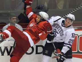 In this file photo, Western Mustangs Julian Cimadamore (right) checks McGill Redman Francis Verreault-Paul along the boards during the first period of the 2012 CIS men's ice hockey championship game on Sunday, March 25, 2012 in Fredericton, New Brunswick. The occurrence of brain-rattling concussions among both elite male and female hockey players appears to be much higher than reported, suggests a study in which sports medicine doctors were behind the bench observing a season's worth of games. THE CANADIAN PRESS/Mike Dembeck.