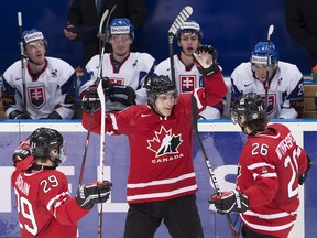 Canada forward Ryan Strome, centre, celebrates his goal with teammates Jonathan Drouin, left, and Tyler Wotherspoon, right, after scoring a goal against Slovakia during third period IIHF World Junior Championships hockey action in Ufa, Russia on Friday, Dec. 28, 2012. THE CANADIAN PRESS/Nathan Denette