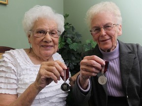 Kay Crothers, 97, left, and Lois Thurgood, 91,  are all smiles as they display their Queen Elizabeth II Diamond Jubilee Medal on Thursday December 6, 2012.   The awards were presented by MP Teresa Piruzza representing the Governor General.   JASON KRYK/ The Windsor Star)