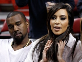 Kim Kardashian, right, and Kanye West, left, are shown before an NBA basketball game between the Miami Heat and the New York Knicks in this Dec, 6, 2012 file photo taken in Miami. The rapper Kanye West announced at a concert Sunday night Dec. 30, 2012 that his girlfriend is pregnant. He told the crowd of more than 5,000 at the Ovation Hall at the Revel Resort in song form: "Now you having my baby." ( AP Photo/Alan Diaz, File)