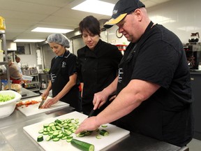Toni Maceroni, chef and co-owner of La Zingara, instructs  Daysi Mendoza, left,  and Chris Little during food preparation training at the Downtown Mission on November 28, 2012 in Windsor, Ontario.  (JASON KRYK/ The Windsor Star)