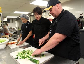 Toni Maceroni, chef and co-owner of La Zingara, instructs  Daysi Mendoza, left,  and Chris Little during food preparation training at the Downtown Mission on November 28, 2012 in Windsor, Ontario.  (JASON KRYK/ The Windsor Star)