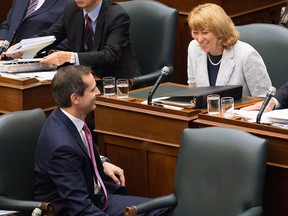 Ontario Premier Dalton McGuinty, left, and Ontario Education Minister Laurel Broten, right, speak to one another before the Liberal party and the Progressive Conservative party passed an anti-strike bill that cuts benefits and limits wages for Ontario teachers at Queens Park in Toronto on Tuesday, September 11, 2012. THE CANADIAN PRESS/Michelle Siu