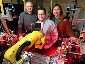 Nick Dimitrov, left, Ross Rawlings and Shelley Fellows of Radix Inc.pose with their cross-member assembling and inspecting station.  (NICK BRANCACCIO/The Windsor Star)